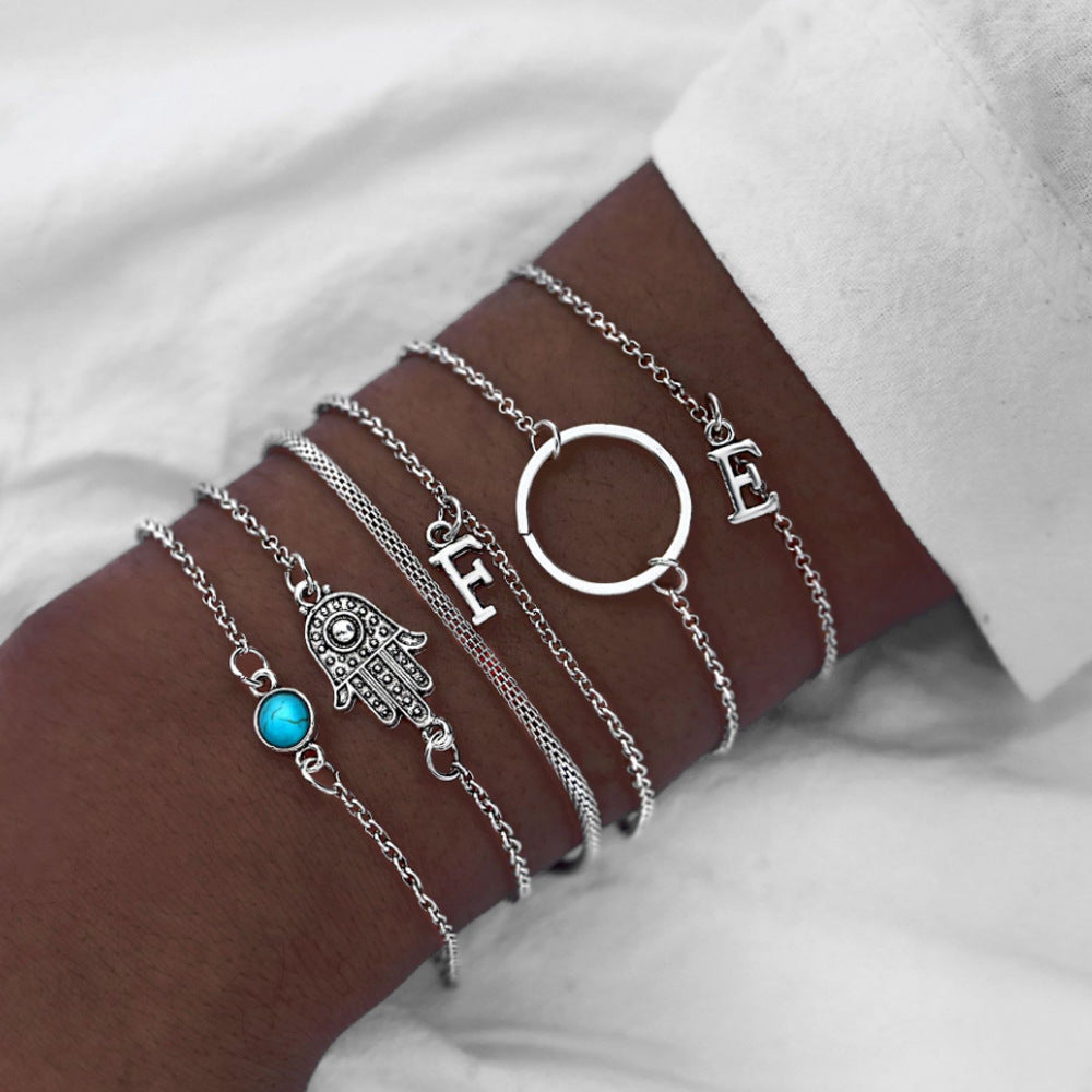 Vier­teiliges Armband-Set mit schwarzen Perlen, Herz-, Blatt- und Lotusmotiv