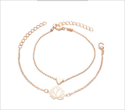 Vier­teiliges Armband-Set mit schwarzen Perlen, Herz-, Blatt- und Lotusmotiv